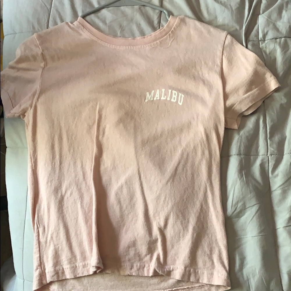 a light pink shirt sleeve shirt that said “Malibu”